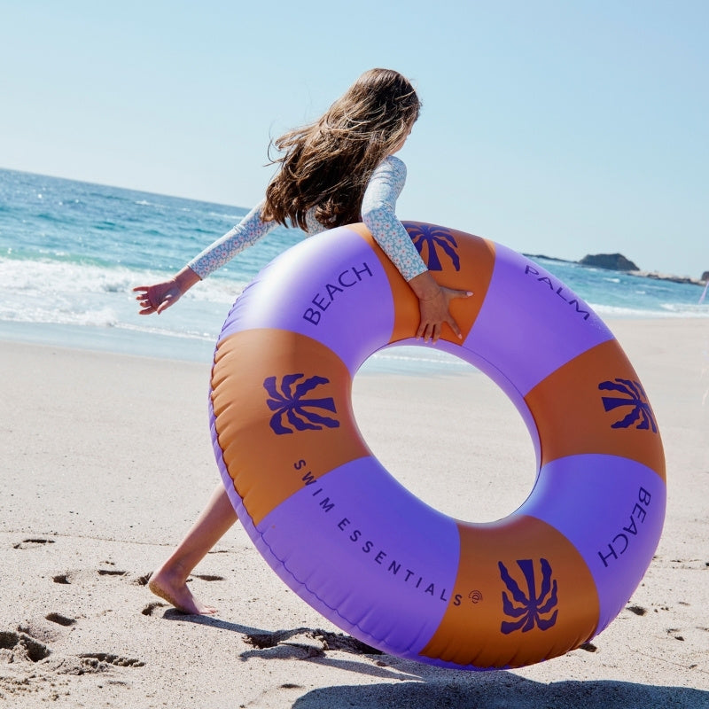 twee meisjes in uv werende zwemkleding op het strand 
